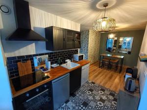 a kitchen with a sink and a counter top at Le Duplex des Arcades - T2 lumineux hypercentre in Carentan