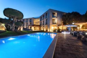a swimming pool in front of a building at night at Hotel & Spa Golden Barcelona in Vallromanas