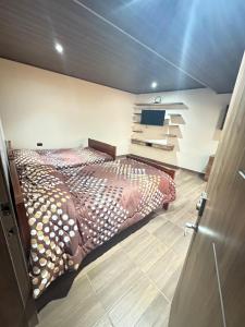 ein Schlafzimmer mit einem Bett und einem Fernseher darin in der Unterkunft CASACAMPO Inn in Ibarra