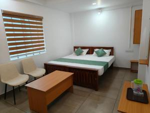 a bedroom with a bed and a table and chairs at Skyline Inn in Anachal