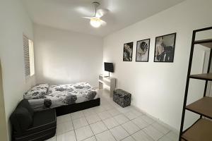 a white bedroom with a bed and a lamp at Lindo Sala Living com vista para o Mar in Santos