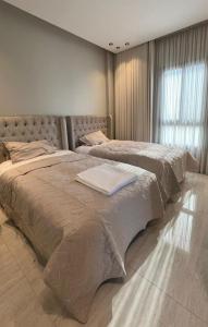 een slaapkamer met 2 bedden en een raam erin bij Alsoltan stay in Dammam
