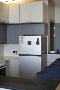een keuken met een witte koelkast en witte kasten bij Alsoltan stay in Dammam