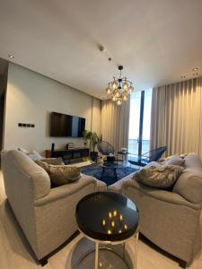 een woonkamer met twee banken en een tafel bij Alsoltan stay in Dammam