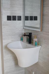 een witte wastafel in een badkamer met een spiegel bij Alsoltan stay in Dammam +35 foto's