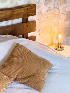 a bed with a pillow and a lamp on a table at Le Logis de cœur in Azay-le-Rideau