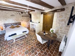 a bedroom with a bed and a wooden table at Le Logis de cœur in Azay-le-Rideau