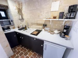 a kitchen with a sink and a white counter top at Le Logis de cœur in Azay-le-Rideau