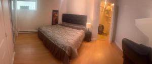 1 dormitorio con 1 cama en una habitación pequeña en Perfect location brand new basement 3 and half appartment, en Laval 1 foto más