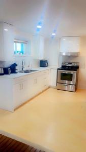 a kitchen with white cabinets and a stove top oven at Perfect location brand new apartment in Laval