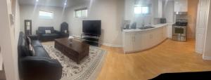a living room with a couch and a table and a kitchen at Perfect location brand new apartment in Laval