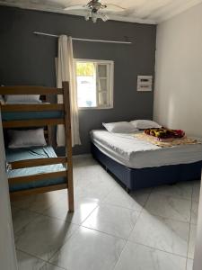 Un dormitorio con dos literas y una ventana. en Casa 140, en Guarujá
