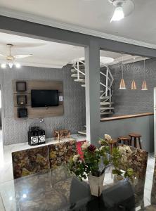 Una sala de estar con un televisor en la pared. en Casa 140, en Guarujá