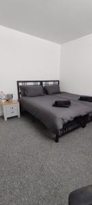 a bedroom with a large bed with a night stand at Quality Rooms in Liverpool