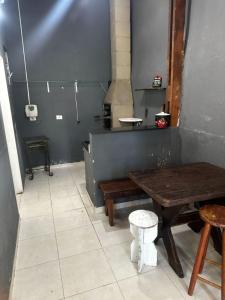 cocina con mesa, mesa y taburete en Casa 140, en Guarujá