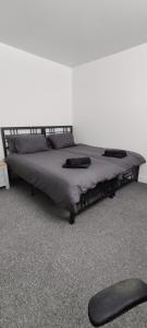 a large bed in a white room with a bedskirtspectspectspects at Quality Rooms in Liverpool