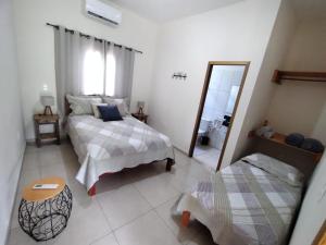 Un dormitorio con dos camas y un espejo. en Suíte Encanto do Paraíso - Cozinha - Self check-in, en Torrinha