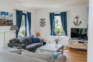 a living room with two couches and a tv at Vakantiewoning Ouddorp - kindervriendelijk in Ouddorp