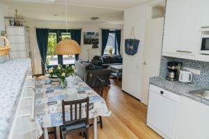 a kitchen and living room with a table and chairs at Vakantiewoning Ouddorp - kindervriendelijk in Ouddorp