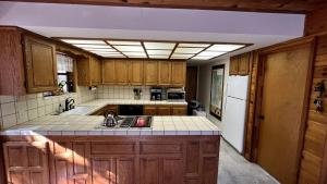 a kitchen with wooden cabinets and a white refrigerator at Little Bear Lodge, Located in Ponderosa California in Springville +40 photos