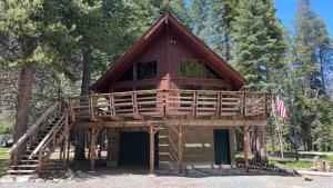 a tree house with a deck on top of it at Little Bear Lodge, Located in Ponderosa California in Springville
