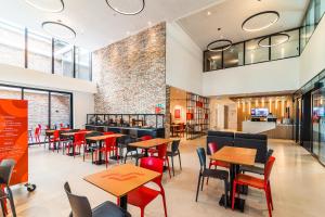 a restaurant with tables and chairs and a brick wall at Hotel Moov Porto Alegre in Porto Alegre