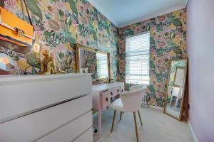 a bedroom with floral wallpaper and a desk and a mirror at Moody Street in Congleton