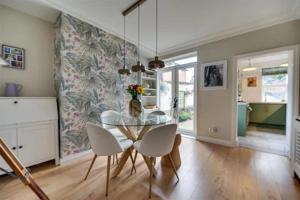 a dining room with a glass table and white chairs at Moody Street in Congleton