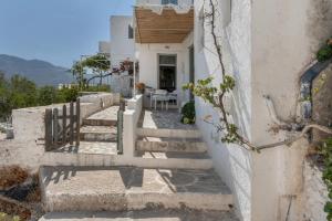 a staircase leading up to a house with a table at Traditional Hora House Serifos in Serifos Chora