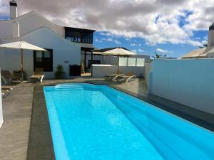 a swimming pool in front of a house at Nazaret Villa with heated pool in Nazaret