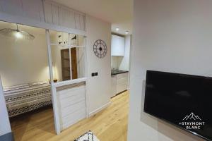 a kitchen with a sliding door and a clock on a wall at Charmant 2 pièces cosy au cœur de Saint-Gervais in Saint-Gervais-les-Bains +2 photos