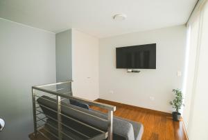 a staircase with a flat screen tv on a wall at Duplex Moderno y Espacioso en Miraflores in Lima