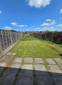 un champ d'herbe à côté d'une clôture dans l'établissement Lovely 4 Bed Dudley Home, à Sedgley