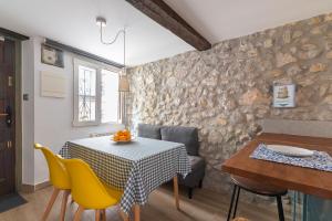 a dining room with a table and yellow chairs at La casa de Santa María in Laredo +16 photos
