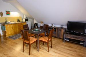 a dining room with a table and chairs and a television at Apartmán Linda Tále in Tale