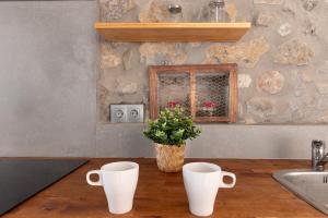 a kitchen counter with two white cups and a plant at La casa de Santa María in Laredo