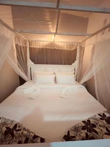 a bed in a small room with white sheets and pillows at Amurasan beach studio in Tangalle