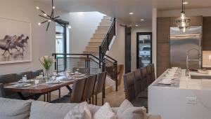 a dining room with a table and a staircase at Princetown Grande in Steamboat Springs