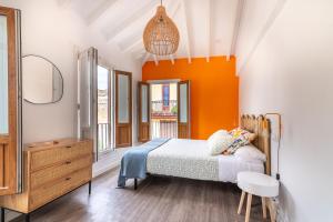 a bedroom with a bed with an orange wall at La casa de Santa María in Laredo
