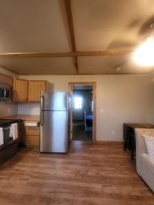a kitchen with a stainless steel refrigerator in a room at Cottage 2 on Ranch with Fishing & Camping in McKinney