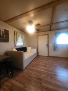 a living room with a white couch and a window at Cottage 2 on Ranch with Fishing & Camping in McKinney