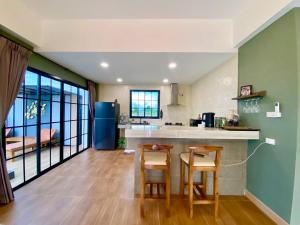 a kitchen with a counter and two chairs in a room at Mimi Pool Villa Chiangmai in Chiang Mai
