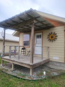 a house with a deck with a sunflower on it at Cottage 2 on Ranch with Fishing & Camping in McKinney +10 photos