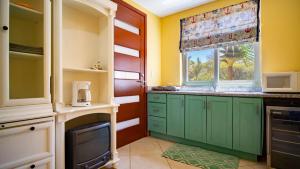 a kitchen with green cabinets and a window at casa del mar in San Rafael del Sur