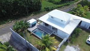 an overhead view of a white house with a swimming pool at Villa Manakit in Petit-Bourg