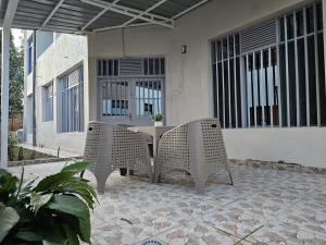 um pátio com duas cadeiras e uma mesa em frente a uma casa em Little Paradise em Kigali