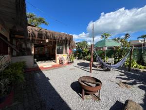 a store with a hammock and an umbrella in front at Tia Chica Camburi in Camburi