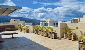 a rooftop patio with potted plants on a building at Luxury San Jose aptartment Central&Chic in San José