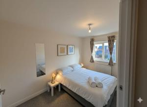 een slaapkamer met een bed met twee witte handdoeken erop bij Woodley Haven House in Woodley