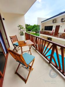 a balcony with a table and chairs on it at Makadal'Eau Boutique Resort in Siquijor